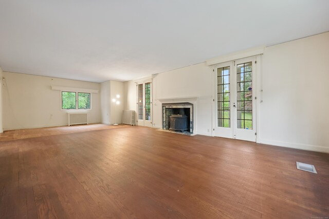 16 Katydid Ln, Weston, CT 06883 - unfurnished living room with wood finished floors, a fireplace with flush hearth, radiator, and baseboards