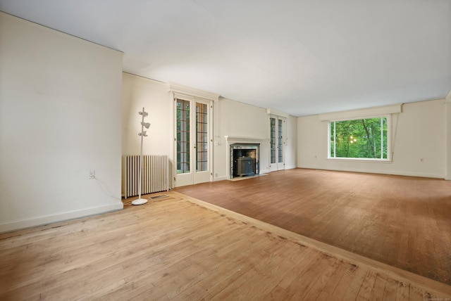 16 Katydid Ln, Weston, CT 06883 - unfurnished living room with radiator, hardwood / wood-style floors, a fireplace with flush hearth, and baseboards