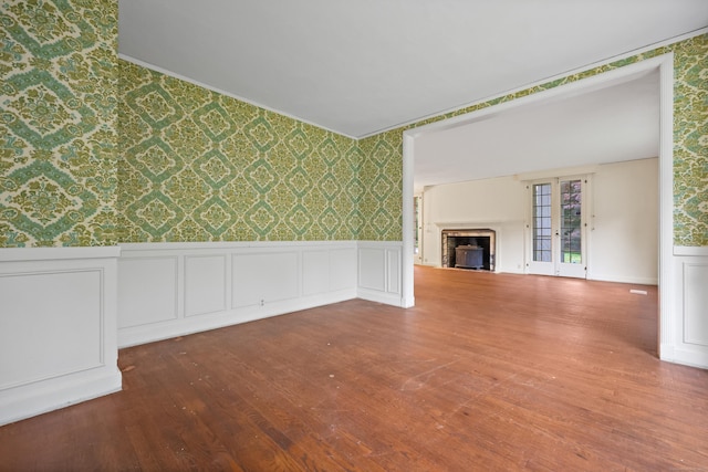 16 Katydid Ln, Weston, CT 06883 - unfurnished living room with wallpapered walls, wood finished floors, wainscoting, a fireplace, and a decorative wall