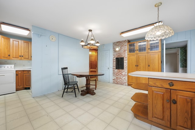 16 Katydid Ln, Weston, CT 06883 - kitchen featuring washer / dryer, light countertops, brown cabinetry, and pendant lighting