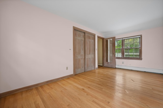 16 Katydid Ln, Weston, CT 06883 - unfurnished bedroom with baseboard heating, light wood finished floors, baseboards, and a closet