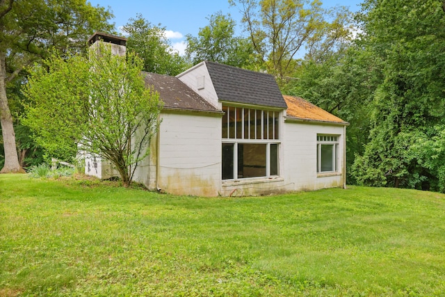 16 Katydid Ln, Weston, CT 06883 - view of side of home with a shingled roof, a yard, and concrete block siding