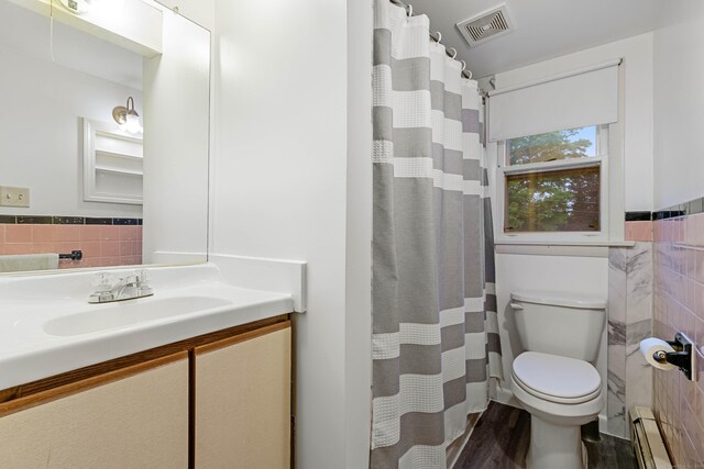 332 Shewville Rd, Ledyard, CT 06339 - full bathroom featuring baseboard heating, tile walls, toilet, vanity, and wood finished floors