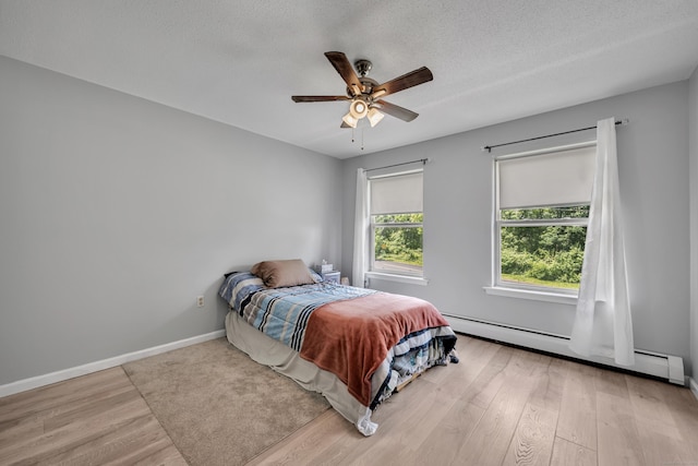 122 Carr Ave, Newington, CT 06111 - bedroom featuring baseboard heating, wood finished floors, baseboards, ceiling fan, and a textured ceiling