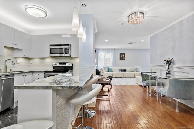 1633 Washington Blvd Unit 3A, Stamford, CT 06902 - kitchen with stainless steel appliances, a sink, a peninsula, a breakfast bar area, and tasteful backsplash