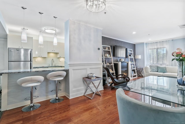 1633 Washington Blvd Unit 3A, Stamford, CT 06902 - kitchen with freestanding refrigerator, wood finished floors, a breakfast bar, crown molding, and a sink
