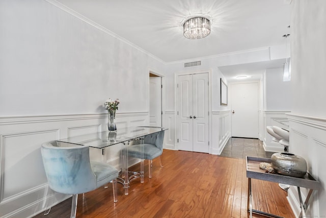 1633 Washington Blvd Unit 3A, Stamford, CT 06902 - dining area featuring a chandelier, wood finished floors, a decorative wall, ornamental molding, and a wainscoted wall