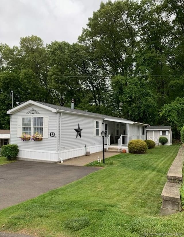 23 N Rd, Southington, CT 06489 - manufactured / mobile home with a front lawn, view of scattered trees, and asphalt driveway