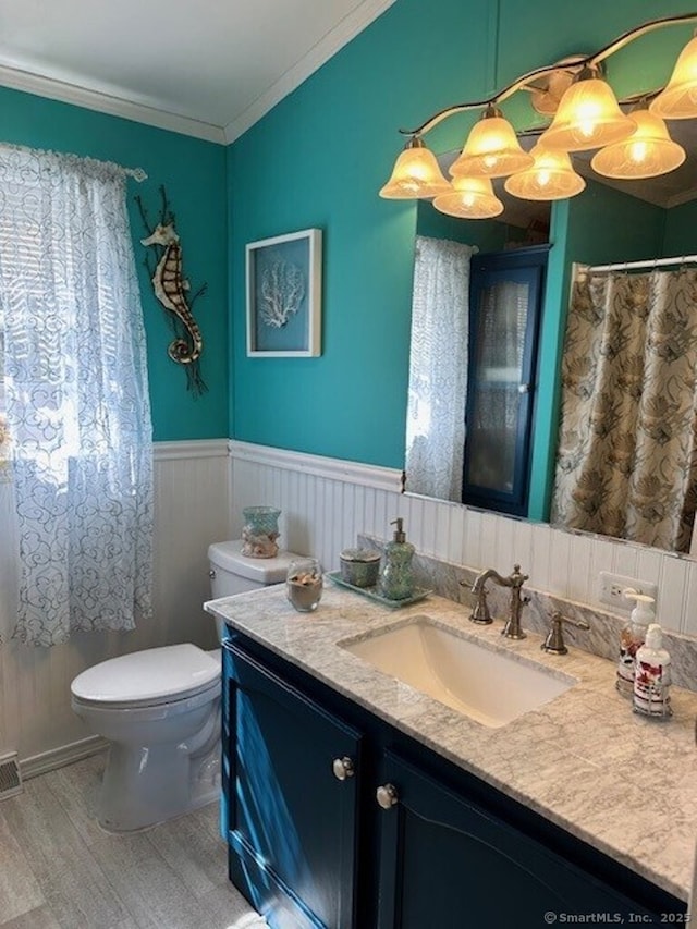 23 N Rd, Southington, CT 06489 - bathroom with vanity, toilet, wood finished floors, wainscoting, and ornamental molding