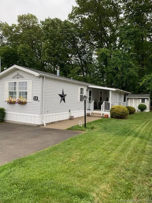 23 N Rd, Southington, CT 06489 - manufactured / mobile home featuring a front lawn, view of wooded area, and driveway