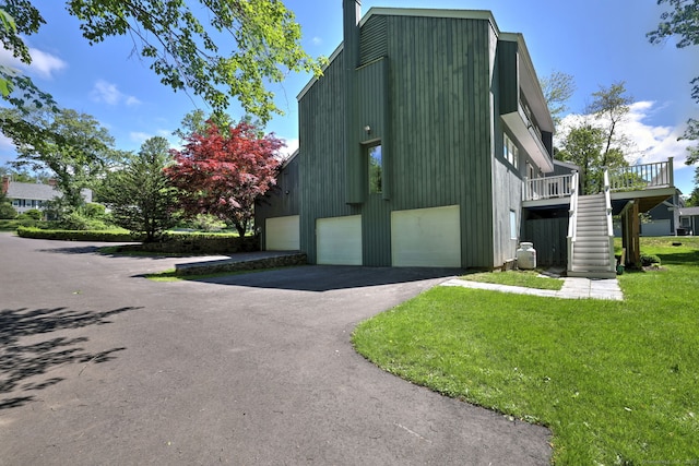 66 Penny Ln, Woodbridge, CT 06525 - view of home's exterior with stairway, a yard, a wooden deck, asphalt driveway, and a chimney
