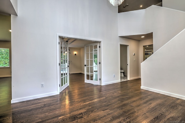 66 Penny Ln, Woodbridge, CT 06525 - unfurnished living room featuring a towering ceiling, wood finished floors, baseboards, and french doors