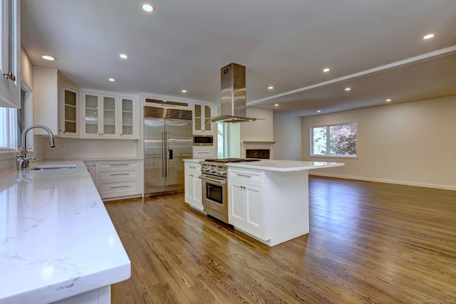66 Penny Ln, Woodbridge, CT 06525 - kitchen with built in appliances, island range hood, a sink, light wood-style floors, and recessed lighting