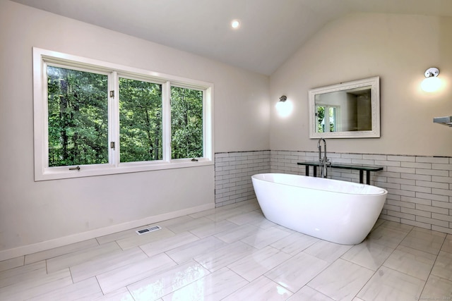 66 Penny Ln, Woodbridge, CT 06525 - bathroom featuring a freestanding bath, tile walls, vaulted ceiling, and wainscoting