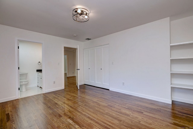 66 Penny Ln, Woodbridge, CT 06525 - unfurnished bedroom with wood finished floors, connected bathroom, and baseboards