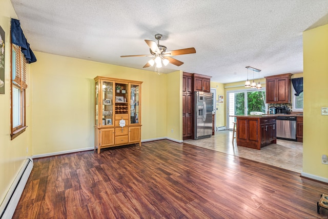 15 Brittany Dr, Durham, CT 06422 - unfurnished living room with baseboard heating, wood finished floors, a ceiling fan, a textured ceiling, and baseboards