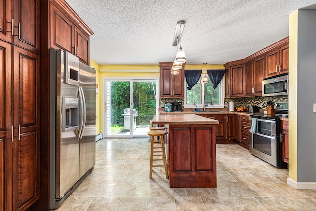 15 Brittany Dr, Durham, CT 06422 - kitchen with appliances with stainless steel finishes, a sink, backsplash, baseboards, and a kitchen island