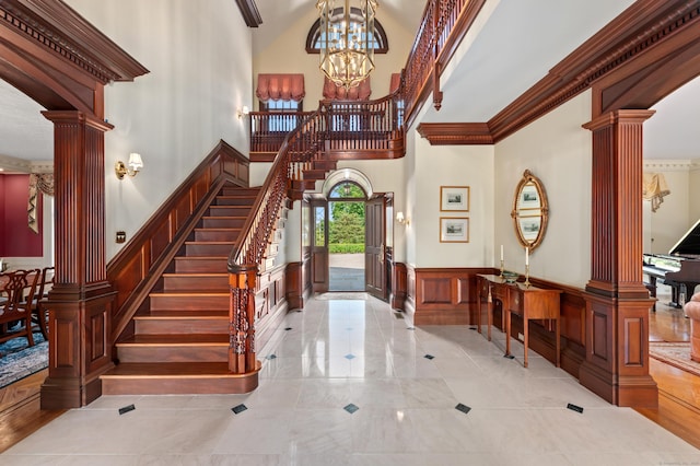 61 High Ridge Ave, Ridgefield, CT 06877 - entryway with ornate columns, wainscoting, a decorative wall, stairway, and a chandelier