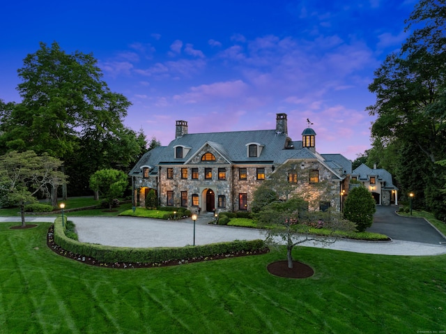 61 High Ridge Ave, Ridgefield, CT 06877 - french provincial home featuring curved driveway, stone siding, a front lawn, and a chimney