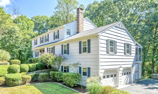 498 Nod Hill Rd, Wilton, CT 06897 - view of front facade featuring a chimney, a garage, driveway, a shingled roof, and view of wooded area