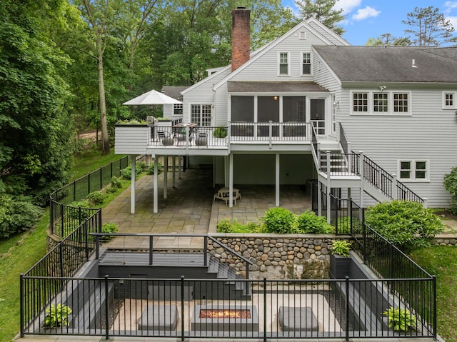 63 Fitch Ln, New Canaan, CT 06840 - back of property with stairway, a patio, a sunroom, and a chimney
