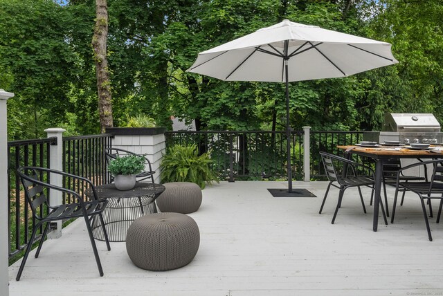 63 Fitch Ln, New Canaan, CT 06840 - deck featuring a grill, view of wooded area, and outdoor dining space