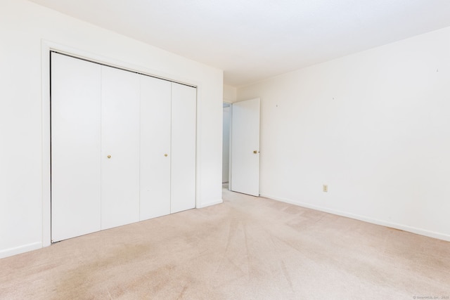 23A Yankee Glen Dr Unit 23A, Madison, CT 06443 - unfurnished bedroom with light colored carpet, a closet, and baseboards