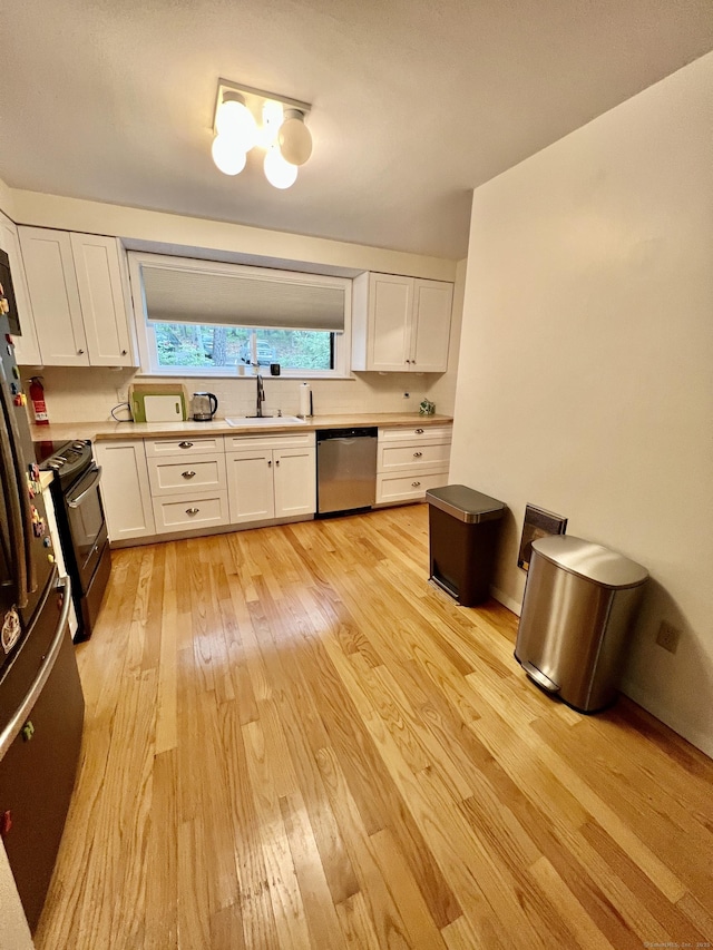 225 Ledge Dr, Torrington, CT 06790 - kitchen with stainless steel dishwasher, black range with electric cooktop, light wood finished floors, and white cabinetry