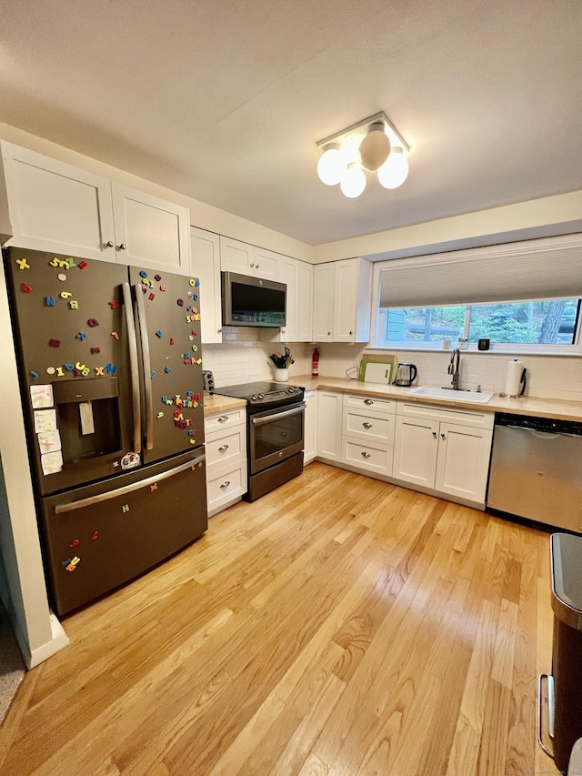 225 Ledge Dr, Torrington, CT 06790 - kitchen with stainless steel appliances, a sink, light wood-style floors, white cabinets, and light countertops