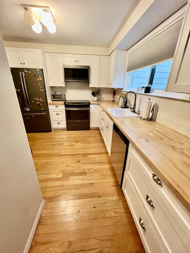 225 Ledge Dr, Torrington, CT 06790 - kitchen with appliances with stainless steel finishes, a sink, backsplash, and white cabinetry
