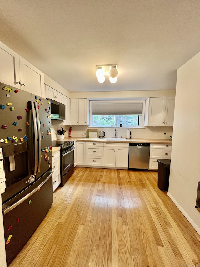 225 Ledge Dr, Torrington, CT 06790 - kitchen featuring stainless steel appliances, white cabinets, light countertops, light wood finished floors, and a sink