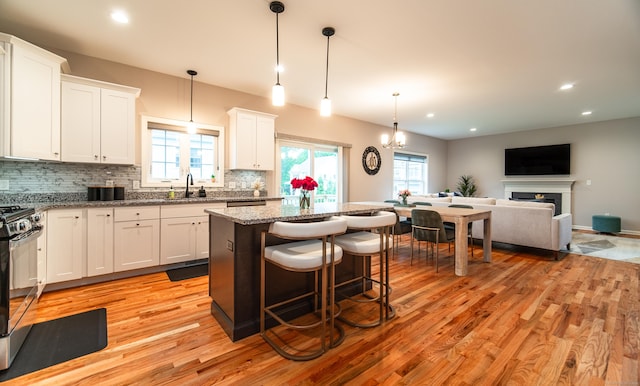 2 Redwood Ln, Southington, CT 06489 - kitchen with a sink, light wood-type flooring, a center island, white cabinetry, and decorative backsplash