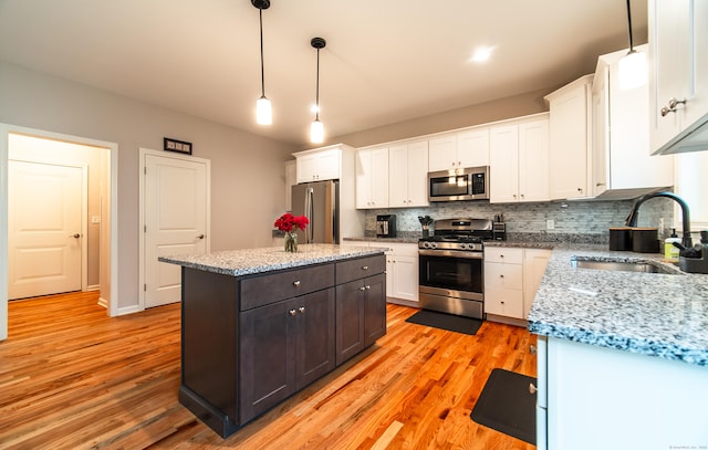 2 Redwood Ln, Southington, CT 06489 - kitchen featuring appliances with stainless steel finishes, a sink, white cabinetry, tasteful backsplash, and a kitchen island