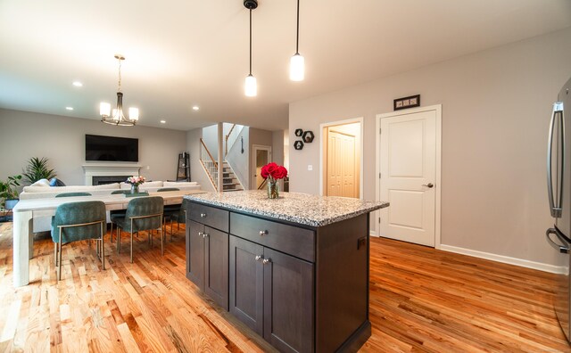 2 Redwood Ln, Southington, CT 06489 - kitchen with light wood-style flooring, a fireplace, pendant lighting, open floor plan, and light stone countertops