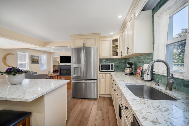 35 Deer Hill Ave, Danbury, CT 06810 - kitchen featuring stainless steel appliances, cream cabinetry, a sink, light wood-style floors, and light stone counters
