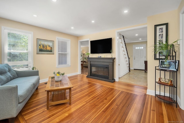 35 Deer Hill Ave, Danbury, CT 06810 - living area featuring baseboards, light wood-type flooring, a glass covered fireplace, recessed lighting, and stairway