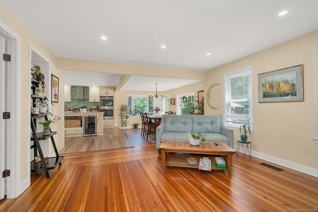 35 Deer Hill Ave, Danbury, CT 06810 - living area with beverage cooler, a chandelier, light wood finished floors, baseboards, and recessed lighting