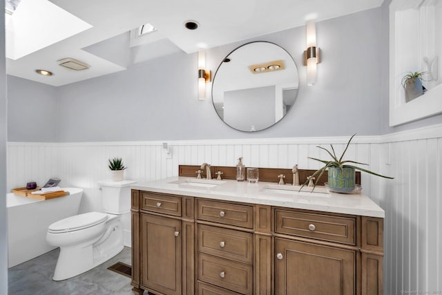 35 Deer Hill Ave, Danbury, CT 06810 - bathroom with double vanity, a wainscoted wall, toilet, and a skylight