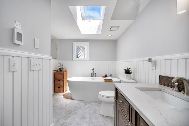 35 Deer Hill Ave, Danbury, CT 06810 - bathroom featuring a skylight, a freestanding tub, wainscoting, vanity, and toilet