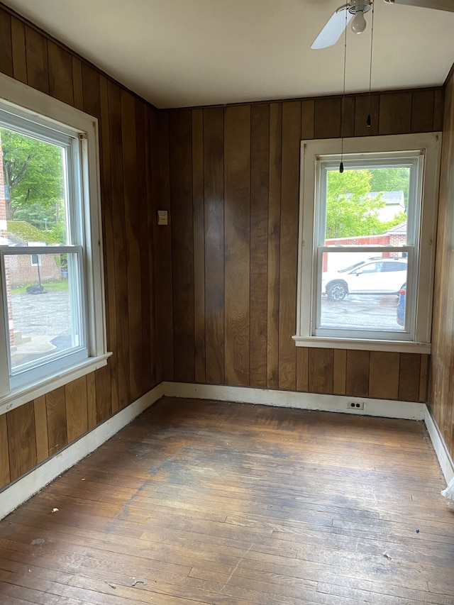 624 S Main St, Torrington, CT 06790 - empty room featuring hardwood / wood-style flooring, plenty of natural light, wood walls, ceiling fan, and baseboards