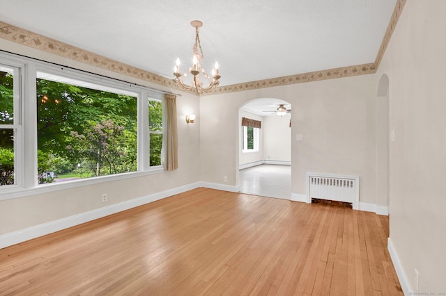172 S Rd, Marlborough, CT 06447 - spare room featuring radiator heating unit, arched walkways, a chandelier, light wood-style floors, and baseboards