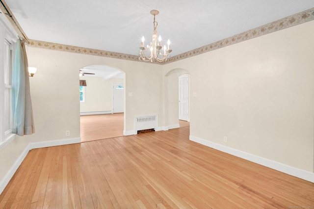 172 S Rd, Marlborough, CT 06447 - empty room with radiator heating unit, arched walkways, light wood-type flooring, a chandelier, and baseboards