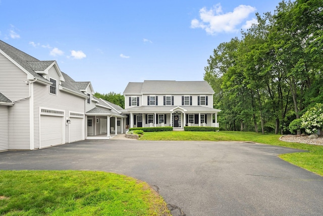 48 Evergreen Rd, Cromwell, CT 06416 - view of front of house featuring a porch, driveway, a garage, and a front lawn
