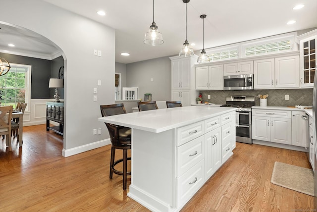 48 Evergreen Rd, Cromwell, CT 06416 - kitchen featuring appliances with stainless steel finishes, a kitchen breakfast bar, arched walkways, a kitchen island, and light countertops