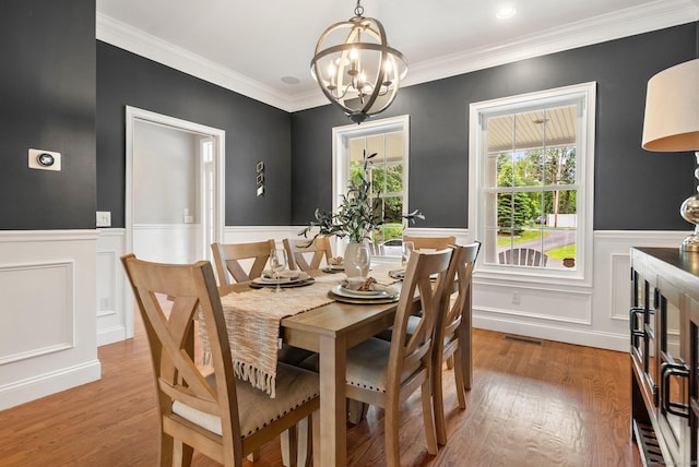 48 Evergreen Rd, Cromwell, CT 06416 - dining room with a chandelier, a wainscoted wall, light wood-style flooring, a decorative wall, and crown molding