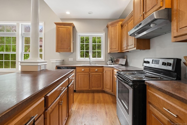 48 Evergreen Rd, Cromwell, CT 06416 - kitchen with electric range, under cabinet range hood, ornate columns, dark countertops, and light wood-style flooring
