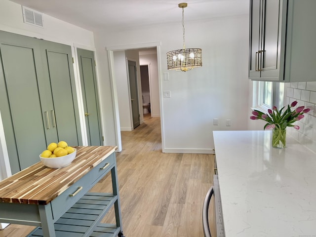 740 Heritage Vlg Unit B, Southbury, CT 06488 - kitchen featuring green cabinets, a chandelier, light wood-type flooring, baseboards, and pendant lighting