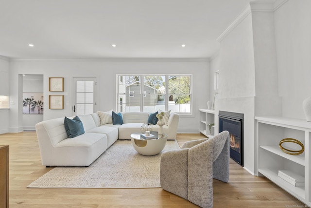 15 Barton Rd, Fairfield, CT 06824 - living room featuring crown molding, a glass covered fireplace, wood finished floors, recessed lighting, and built in shelves