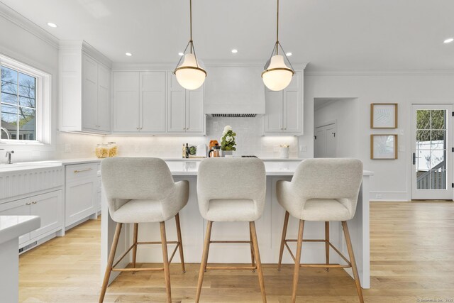 15 Barton Rd, Fairfield, CT 06824 - kitchen with light countertops, decorative backsplash, ornamental molding, a kitchen bar, and a center island