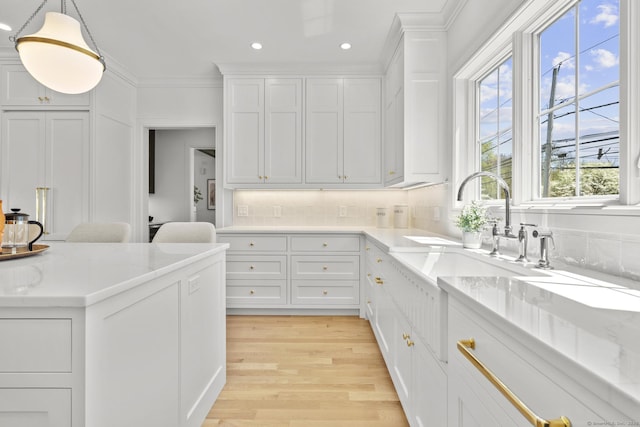 15 Barton Rd, Fairfield, CT 06824 - kitchen featuring light wood finished floors, white cabinets, tasteful backsplash, recessed lighting, and hanging light fixtures